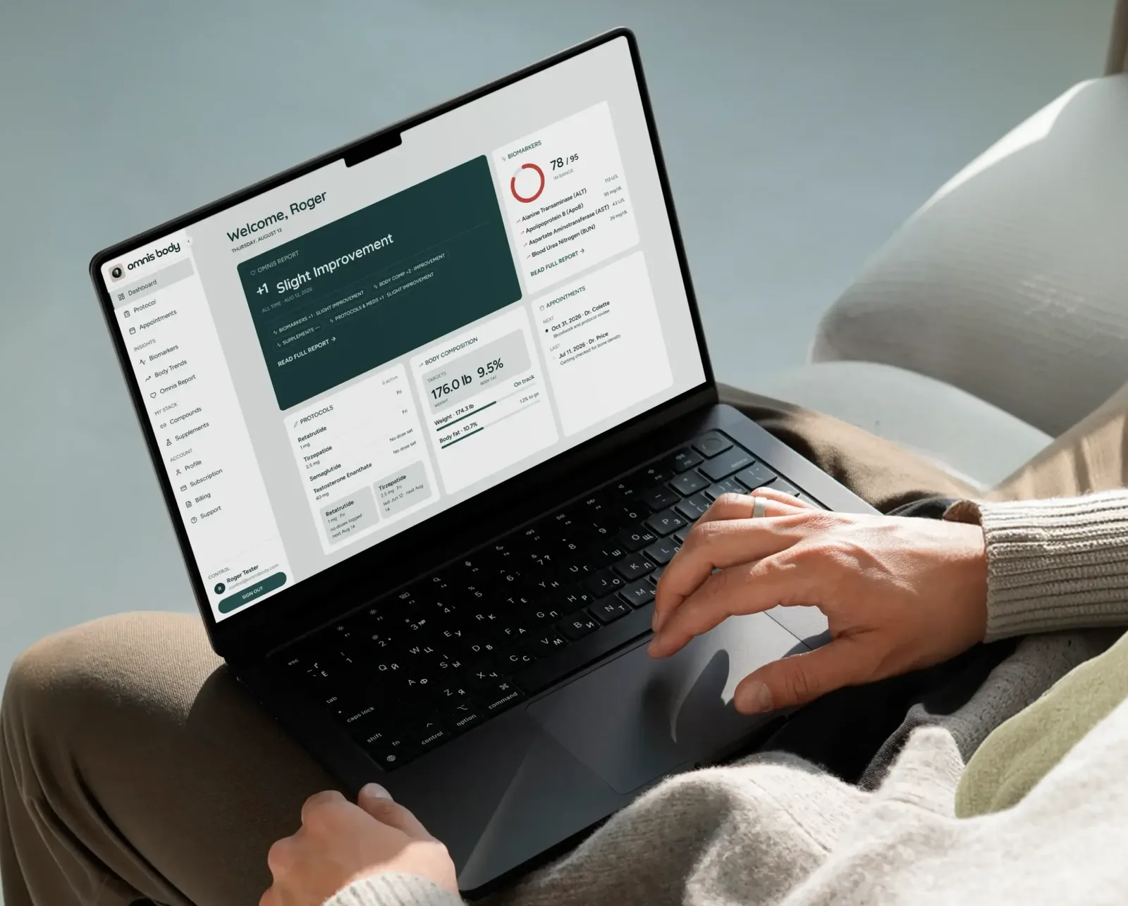 A laptop on someone's lap showing the Omnis Body dashboard.